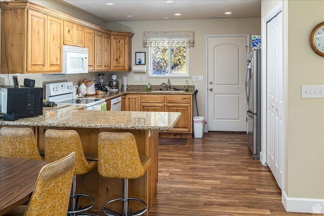 275 W 60 S, Hyde Park, UT 84318 - kitchen featuring white appliances, light stone counters, a kitchen breakfast bar, a peninsula, and a sink