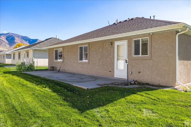 275 W 60 S, Hyde Park, UT 84318 - back of property featuring a shingled roof, a lawn, a patio, a mountain view, and stucco siding
