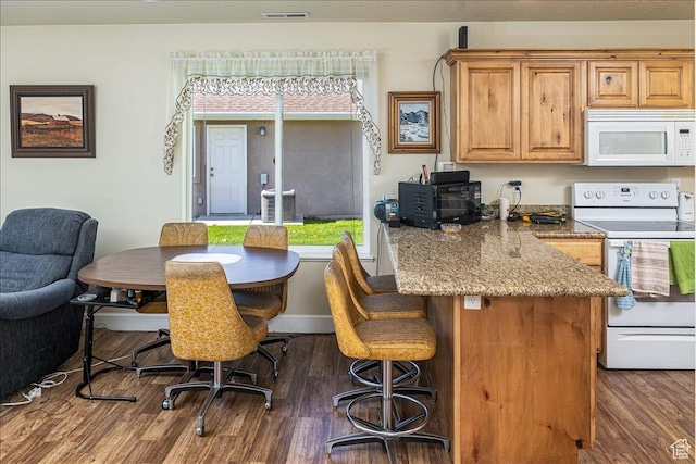 275 W 60 S, Hyde Park, UT 84318 - kitchen with white appliances, visible vents, dark wood-style floors, a breakfast bar area, and light stone countertops