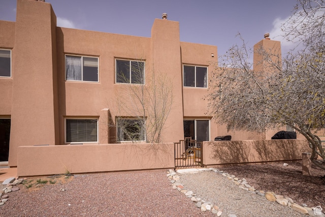 3246 E Fairway Loop, Moab, UT 84532 - rear view of property with a gate, a fenced front yard, and stucco siding