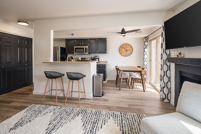 3246 E Fairway Loop, Moab, UT 84532 - kitchen with a breakfast bar area, light wood-style floors, visible vents, and stainless steel appliances