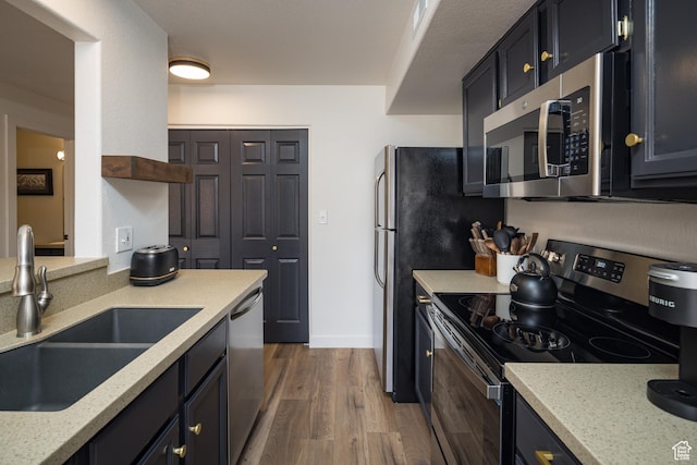 3246 E Fairway Loop, Moab, UT 84532 - kitchen with baseboards, light stone counters, appliances with stainless steel finishes, wood finished floors, and a sink