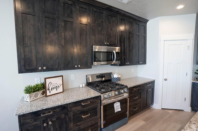 3966 W 2025 S, Taylor, UT 84401 - kitchen featuring light wood-style flooring, appliances with stainless steel finishes, light stone counters, and recessed lighting