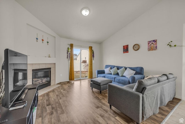 8282 S 6430 W, West Jordan, UT 84081 - living room featuring vaulted ceiling, a tiled fireplace, and wood finished floors