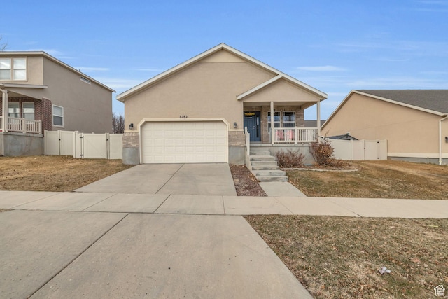 8282 S 6430 W, West Jordan, UT 84081 - view of front facade with an attached garage, covered porch, concrete driveway, a gate, and stucco siding
