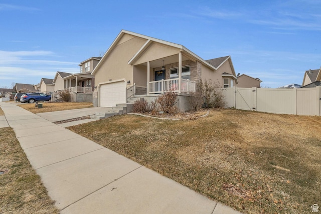 8282 S 6430 W, West Jordan, UT 84081 - view of front of home featuring stucco siding, a porch, concrete driveway, a gate, and a garage