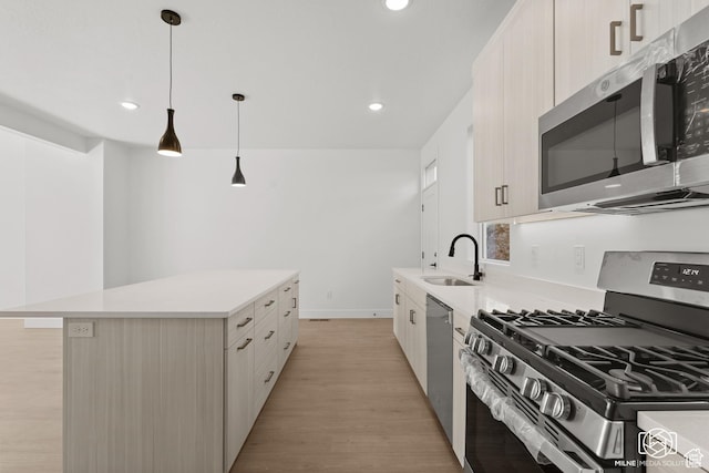 665 E 2015 N # 5E, Cedar City, UT 84721 - kitchen with a center island, stainless steel appliances, light countertops, a sink, and light wood-type flooring