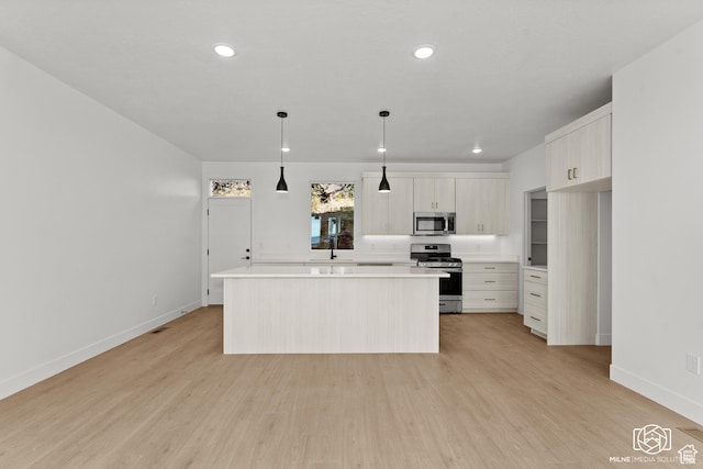 665 E 2015 N # 5E, Cedar City, UT 84721 - kitchen with light countertops, light wood-style flooring, appliances with stainless steel finishes, white cabinets, and a kitchen island