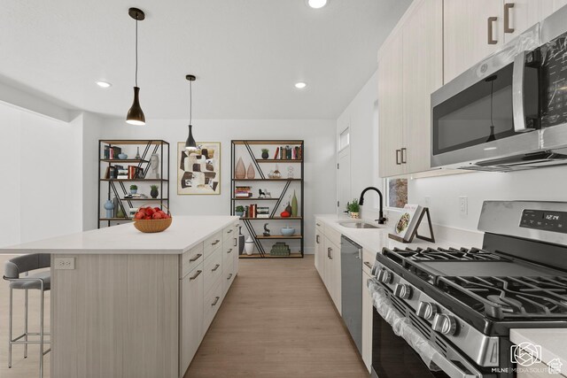 665 E 2015 N # 5E, Cedar City, UT 84721 - kitchen featuring a kitchen island, a kitchen breakfast bar, stainless steel appliances, light countertops, and a sink