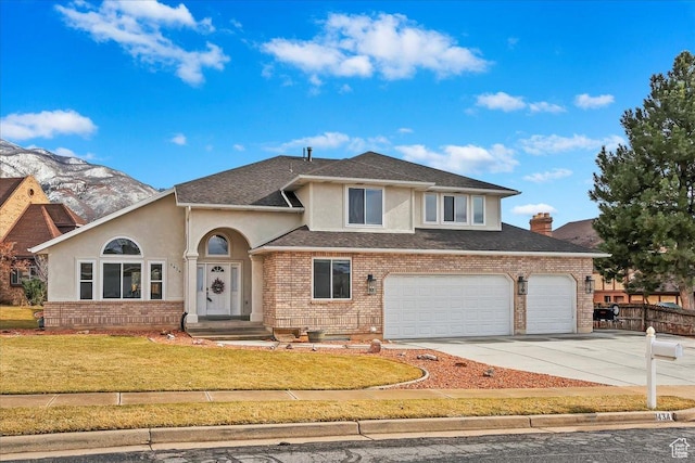 view of front of property with brick siding, concrete driveway, an attached garage, a front yard, and stucco siding
