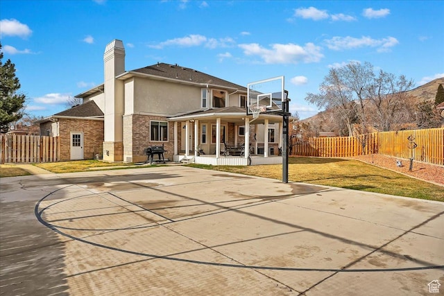 1434 Bennett Cir, Farmington, UT 84025 - rear view of property with covered porch, brick siding, fence, a yard, and stucco siding