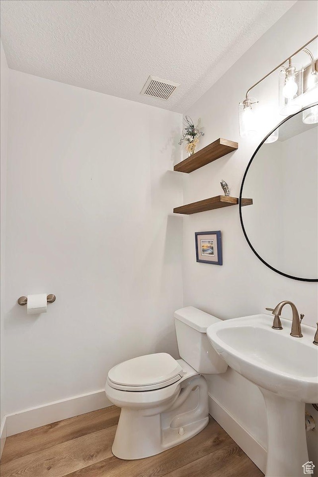 1434 Bennett Cir, Farmington, UT 84025 - half bath featuring toilet, a textured ceiling, visible vents, and wood finished floors