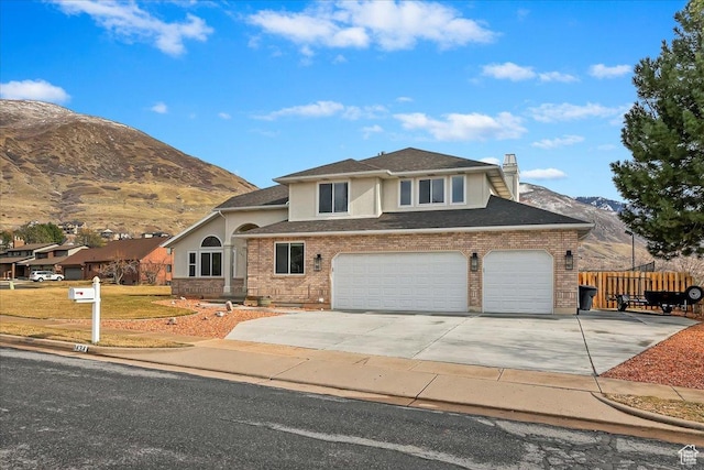 1434 Bennett Cir, Farmington, UT 84025 - view of front of house featuring brick siding, a chimney, fence, a mountain view, and driveway