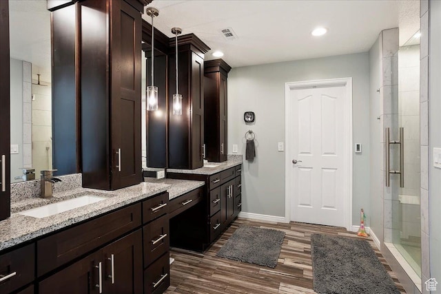 1434 Bennett Cir, Farmington, UT 84025 - full bath with visible vents, a sink, a shower stall, wood finished floors, and baseboards