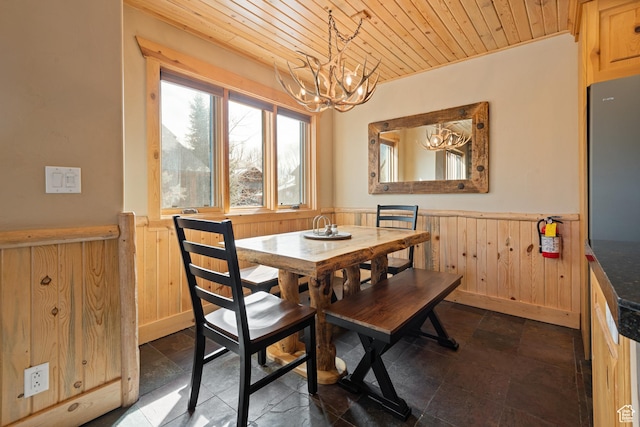 3995 N Timberwolf Ln Unit 1A, Park City, UT 84098 - dining area with wooden ceiling, wooden walls, a wainscoted wall, a notable chandelier, and stone finish floor