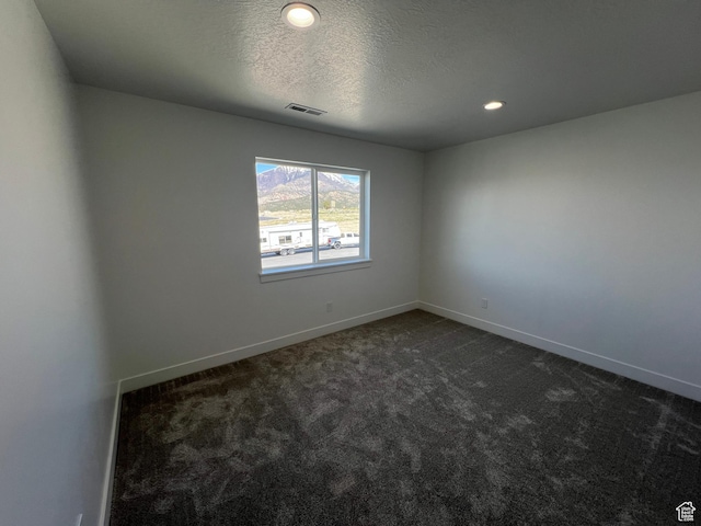 14 E 300 S, Delta, UT 84624 - spare room with a textured ceiling, dark colored carpet, visible vents, and baseboards