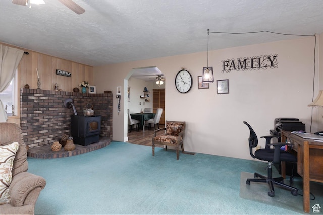 86 E 1000 S, Panguitch, UT 84759 - interior space featuring a wood stove, ceiling fan, arched walkways, and carpet flooring