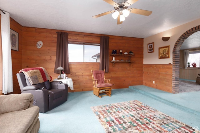 86 E 1000 S, Panguitch, UT 84759 - living area with carpet floors, a textured ceiling, wooden walls, and a ceiling fan