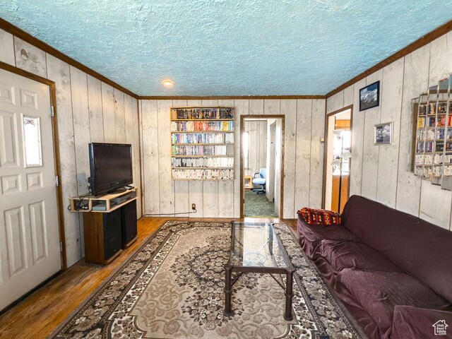138 W 100 N, East Carbon, UT 84520 - living area with ornamental molding, wood finished floors, wooden walls, and a textured ceiling