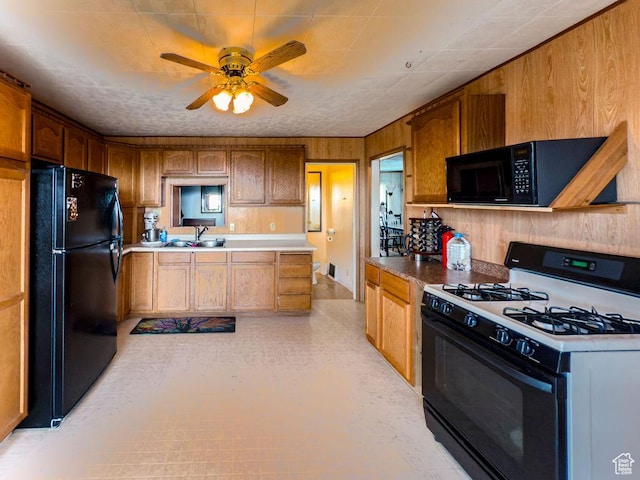 138 W 100 N, East Carbon, UT 84520 - kitchen with black appliances, ceiling fan, wooden walls, brown cabinets, and light countertops