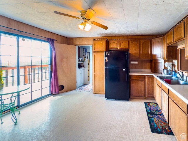 138 W 100 N, East Carbon, UT 84520 - kitchen with freestanding refrigerator, healthy amount of natural light, a ceiling fan, brown cabinets, and wooden walls