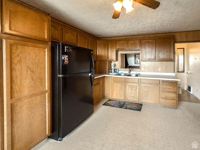 138 W 100 N, East Carbon, UT 84520 - kitchen with freestanding refrigerator, light countertops, ceiling fan, wood walls, and brown cabinets