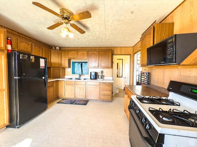 138 W 100 N, East Carbon, UT 84520 - kitchen with a ceiling fan, a sink, black appliances, light countertops, and wood walls