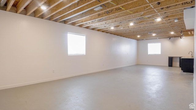 basement featuring a sink and baseboards