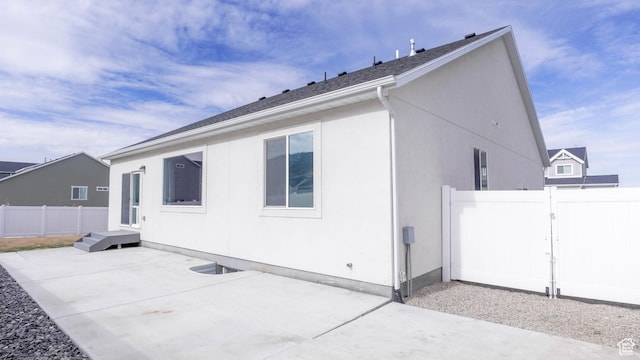 rear view of house with a patio and fence