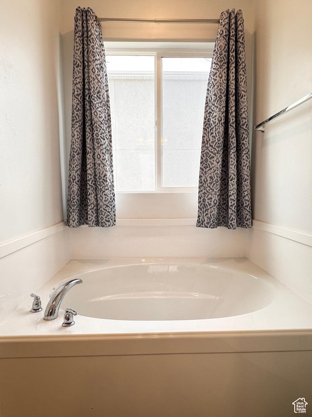 bathroom with plenty of natural light and a bath