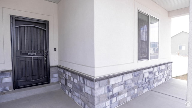 entrance to property featuring stucco siding