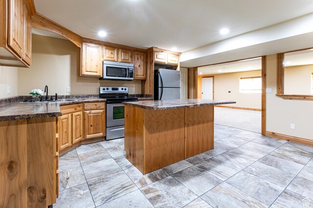 1963 E Rio Way E, Sandy, UT 84093 - kitchen with appliances with stainless steel finishes, a center island, dark countertops, a sink, and baseboards