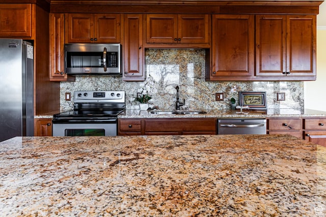 kitchen featuring appliances with stainless steel finishes, brown cabinets, and a sink