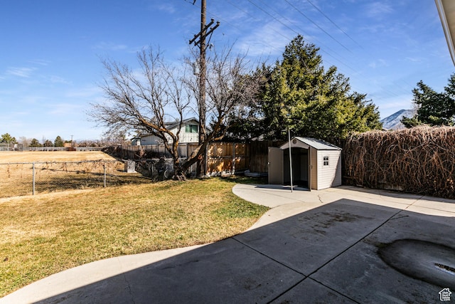view of yard with a fenced backyard, a patio, an outdoor structure, and a shed