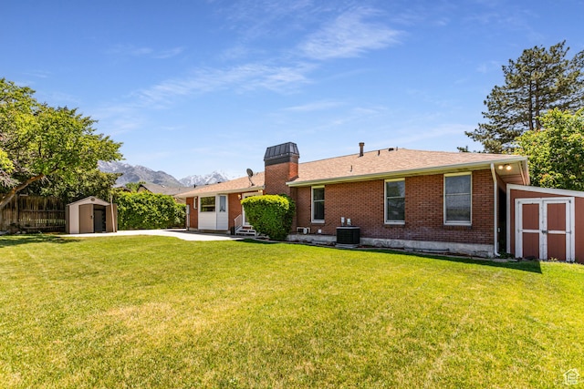 1963 E Rio Way E, Sandy, UT 84093 - rear view of house featuring brick siding, central AC unit, a chimney, a patio area, and roof with shingles