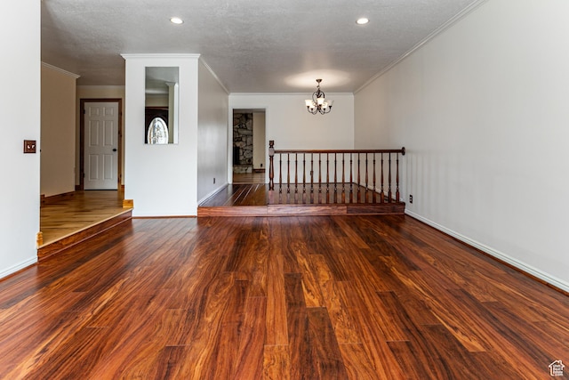 empty room featuring baseboards, a chandelier, and wood finished floors