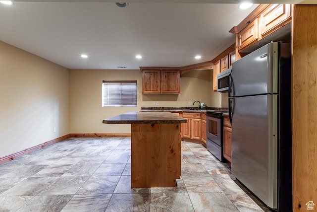 kitchen featuring stainless steel appliances, recessed lighting, a kitchen island, and baseboards