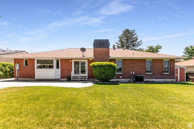 1963 E Rio Way E, Sandy, UT 84093 - back of property featuring entry steps, a patio, a lawn, brick siding, and a chimney