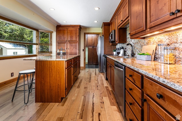 1963 E Rio Way E, Sandy, UT 84093 - kitchen featuring stainless steel appliances, light wood finished floors, a kitchen island, a kitchen bar, and tasteful backsplash