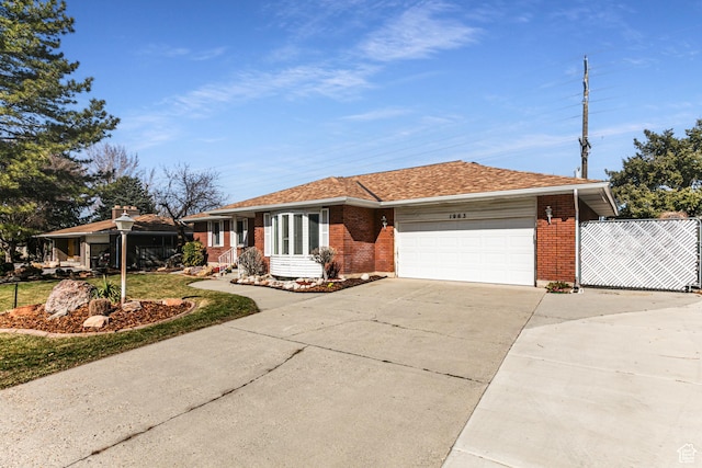 single story home featuring a garage, concrete driveway, brick siding, and roof with shingles