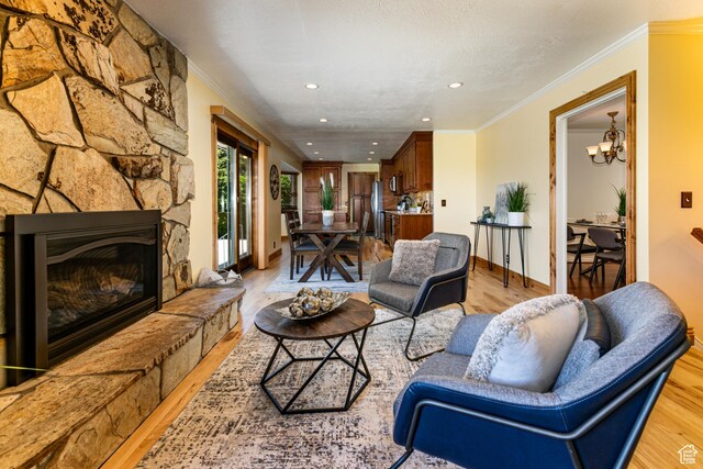 1963 E Rio Way E, Sandy, UT 84093 - living room with light wood-type flooring, recessed lighting, ornamental molding, a chandelier, and a fireplace
