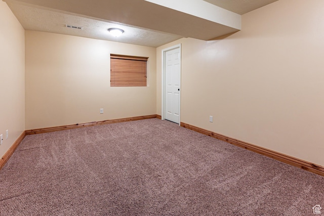 unfurnished room featuring baseboards, a textured ceiling, visible vents, and carpet flooring