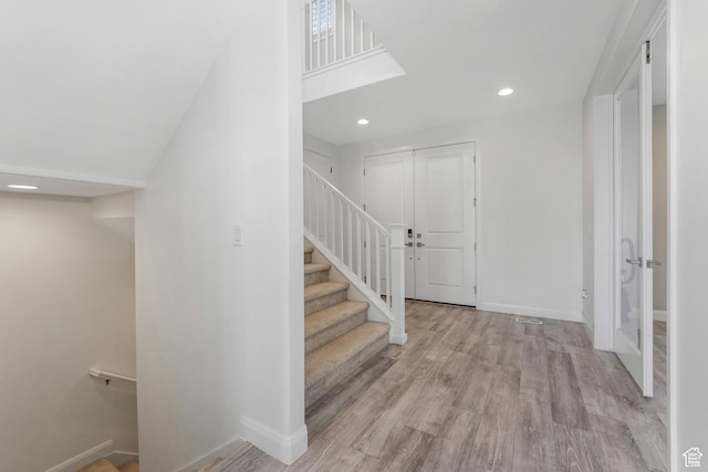 foyer entrance featuring stairway, recessed lighting, baseboards, and wood finished floors