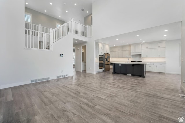 unfurnished living room featuring recessed lighting, visible vents, baseboards, and light wood-style flooring
