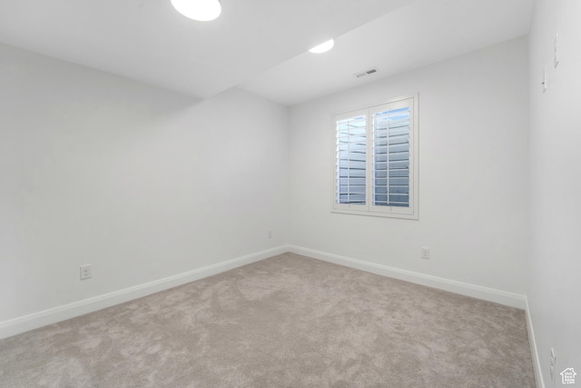 carpeted empty room featuring visible vents and baseboards
