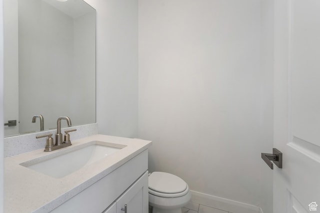 half bath featuring tile patterned flooring, toilet, vanity, and baseboards