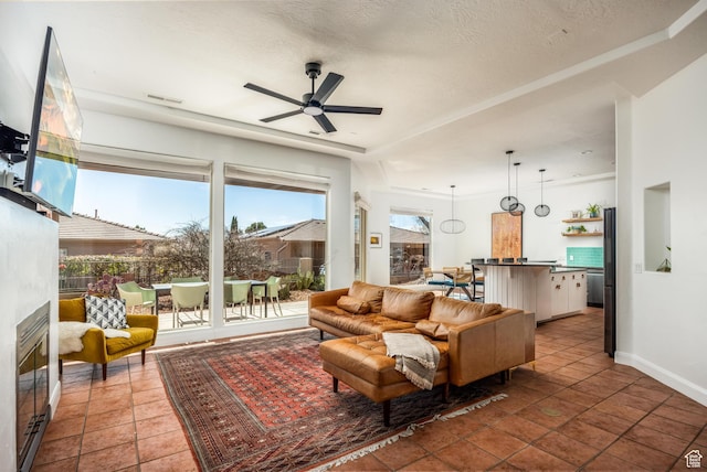 340 N Snow Canyon Dr Unit 4, Ivins, UT 84738 - living area with a textured ceiling, tile patterned flooring, a ceiling fan, baseboards, and a glass covered fireplace