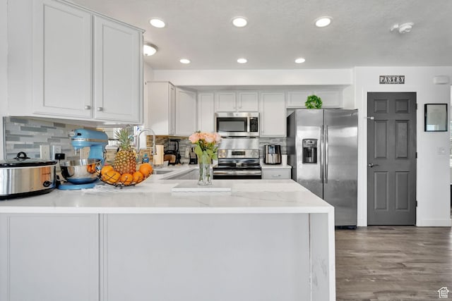 1087 N 1000 W, Clinton, UT 84015 - kitchen with appliances with stainless steel finishes, white cabinetry, a sink, wood finished floors, and a peninsula