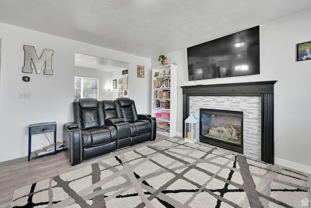 1087 N 1000 W, Clinton, UT 84015 - living room featuring a textured ceiling, a tiled fireplace, wood finished floors, and baseboards