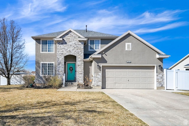traditional-style house featuring fence, stone siding, driveway, stucco siding, and a front yard